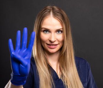 Female dentist wearing scrubs showing number four on black background