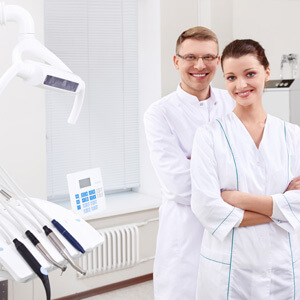 Dental doctors standing beside dental equipment