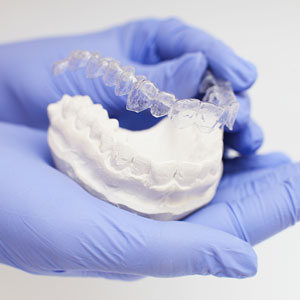 Close-up individual tooth tray in hand invisible braces