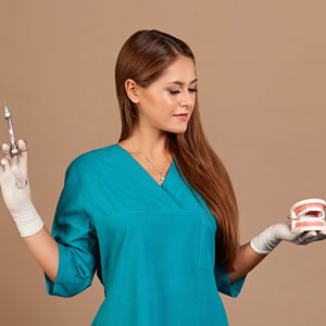 Doctor dentist holding syringe, pursuing dental anesthesia procedure