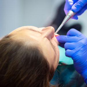 Dentist treat teeth of woman patient in dental clinic