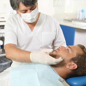 Dentist talking with young patient in dental clinic