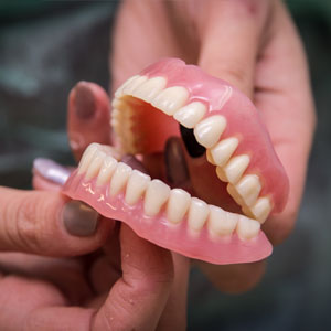 Dentures in the hands prepared for the patient